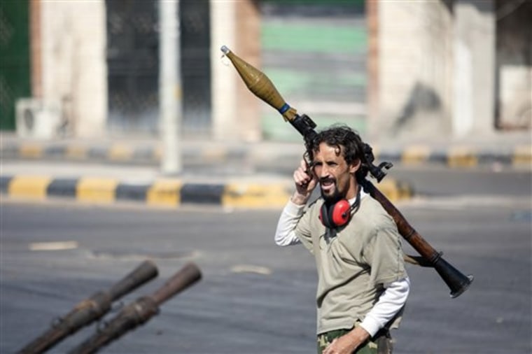 A Libyan rebel fighter carries a rocket-propelled grenade in Sabratha, 50 miles (75 kilometers) west of Tripoli, Libya, Wednesday, Aug. 17, 2011. (AP Photo/Giulio Petrocco)